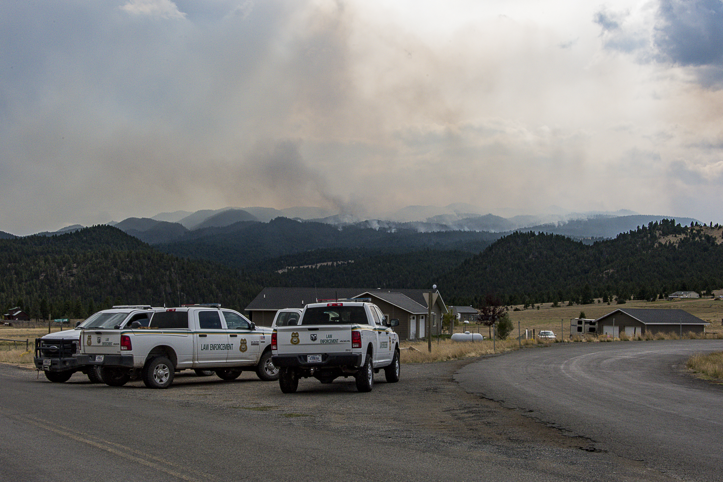 <p>U.S. Forest Service law enforcement personnel, sitting in trucks, are stationed on Little Boulder