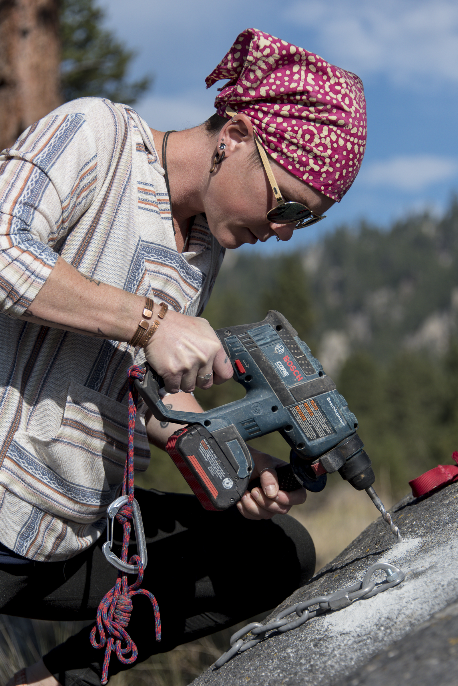 <p>Ravi McKinney, 35, drills into a granite boulder on Sheep Mountain near Clancy to practice instal