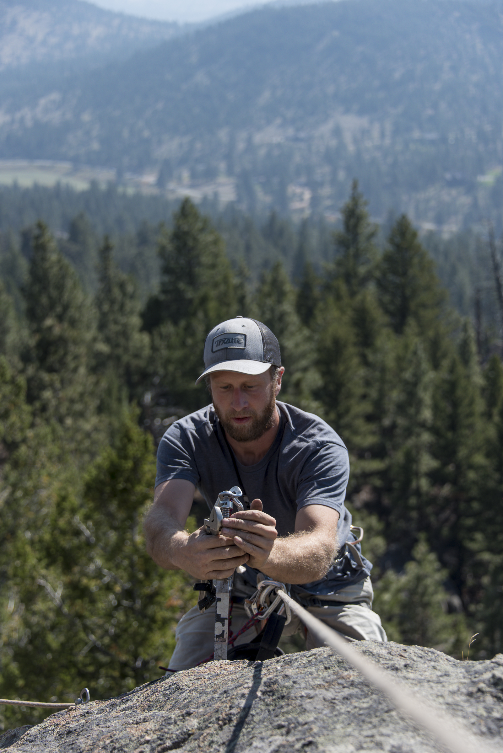 <p>Dan Bachen, 36, removes a bolt at the top of the "School Daze" climbing route on Sheep Mountain n